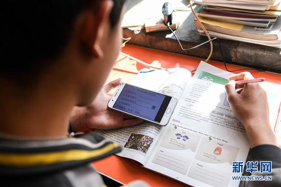  3月10日，內(nèi)蒙古準(zhǔn)格爾旗龍口鎮(zhèn)紅樹梁村的初一學(xué)生劉進(jìn)才在家中上網(wǎng)課。&nbsp;新華社記者 劉磊 攝