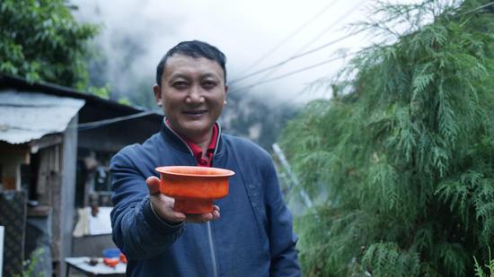  扎西巴珠展示他制作的木碗。新華網(wǎng) 旦增努布攝